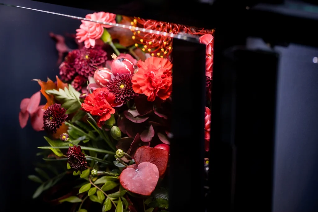 Bukiet czerwonych kwiatów wyeksponowany w szafce Kwiatomatu – przykład merchandisingu florystycznego 24/7