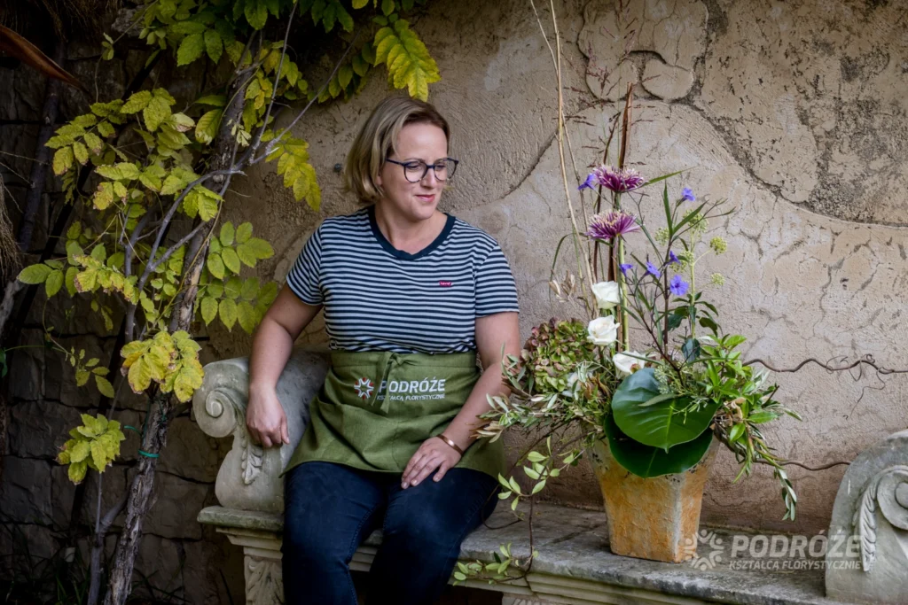 Florystka obserwuje swoją kompozycję kwiatową podczas warsztatów florystycznych – indywidualne podejście do formy