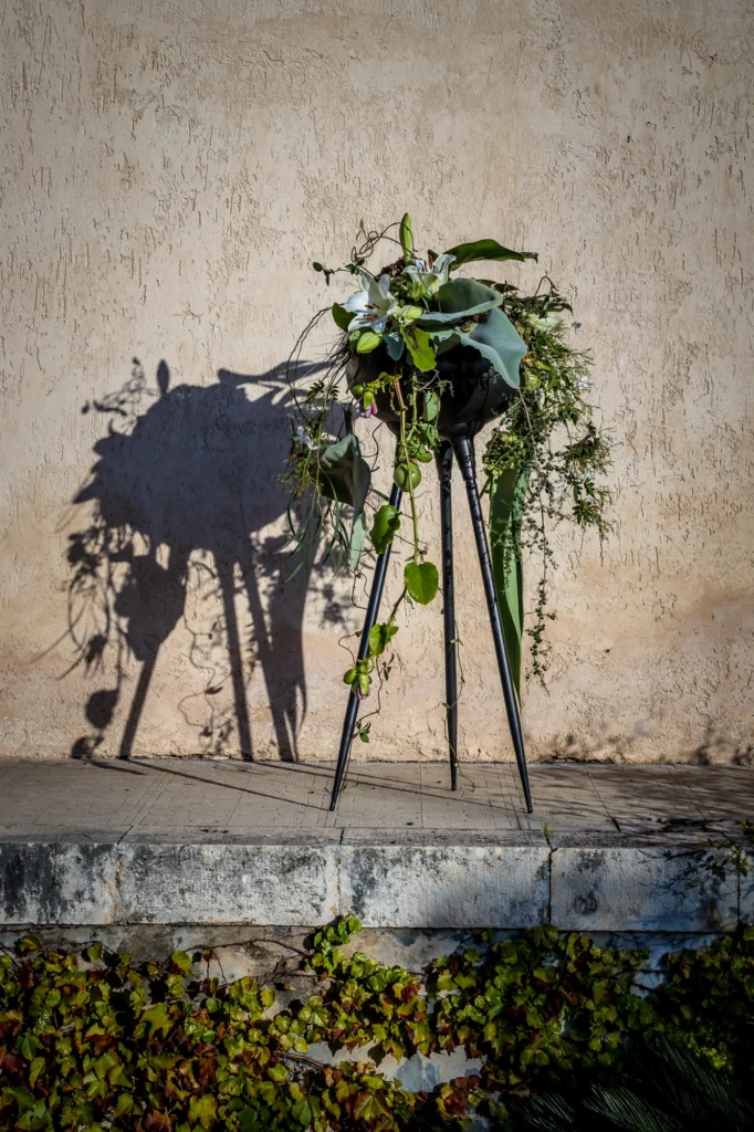 Florysta pracuje nad kompozycją kwiatową na stojaku podczas warsztatów florystycznych