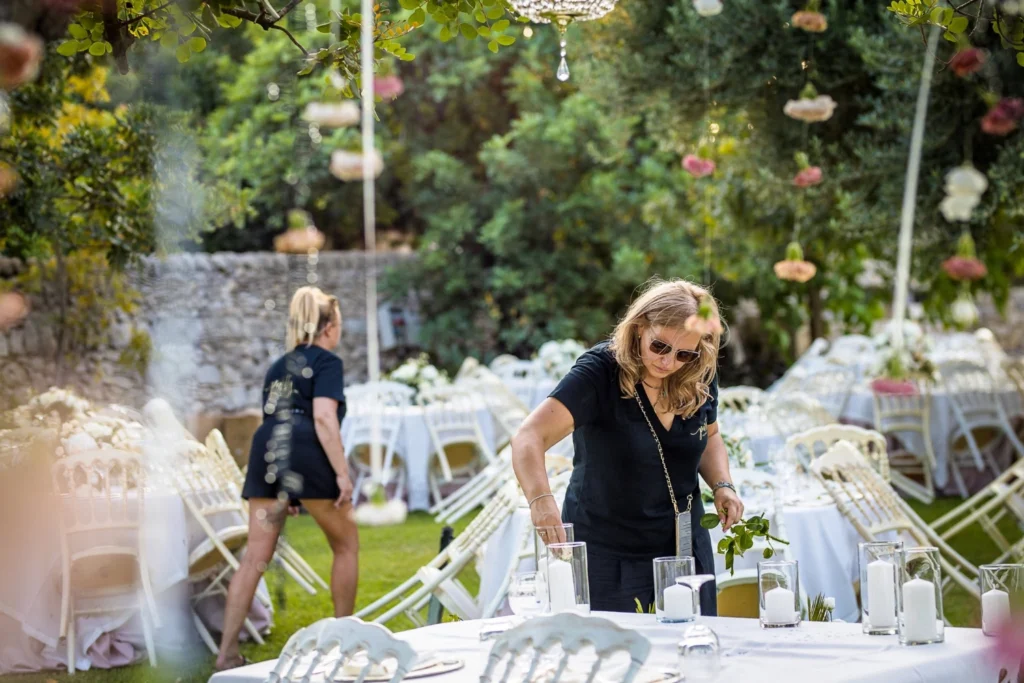 Florystka przygotowująca stoły weselne w ogrodzie Villa Barone Alfieri podczas Party Flowers Workshops