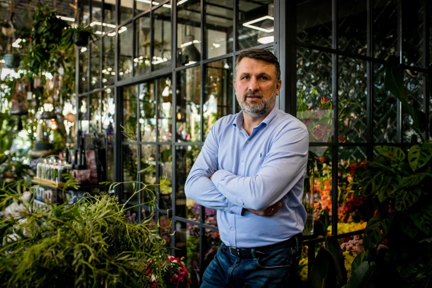 Andrzej Dąbrowski na tle roślin i kwiatów – autor projektu Kwiaciarniane Ewolucje
